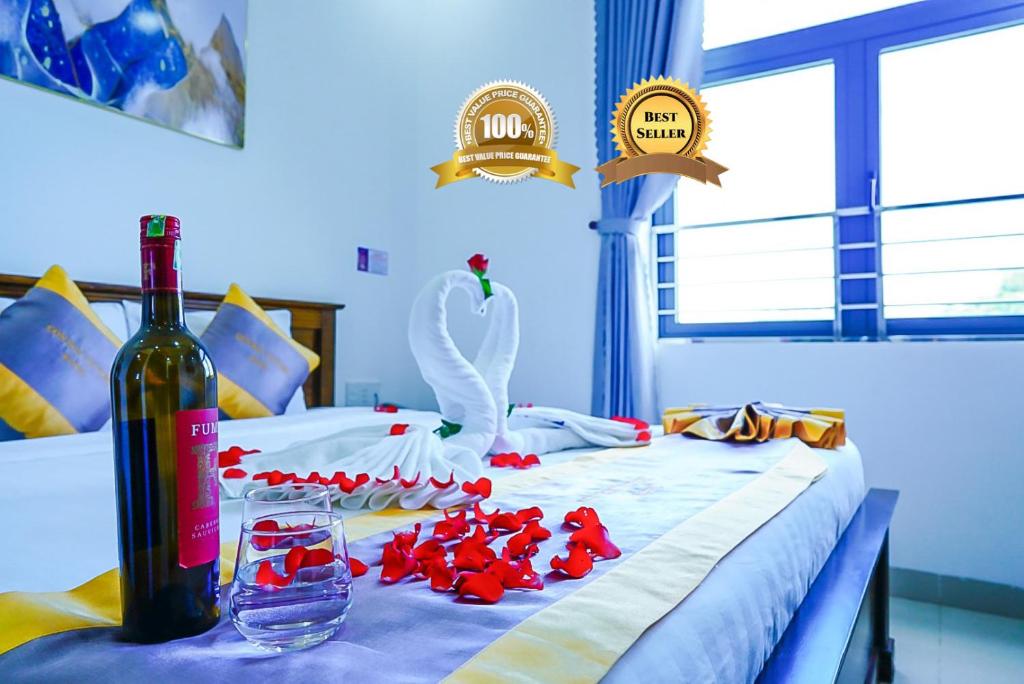 a bed with a bottle of wine and a swan on it at Côn Sơn Victory Hotel in Con Dao