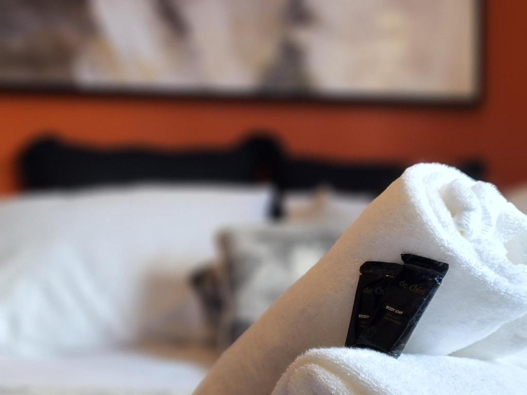 una persona envuelta en una toalla con mando a distancia en The Garston Lodge en Garston
