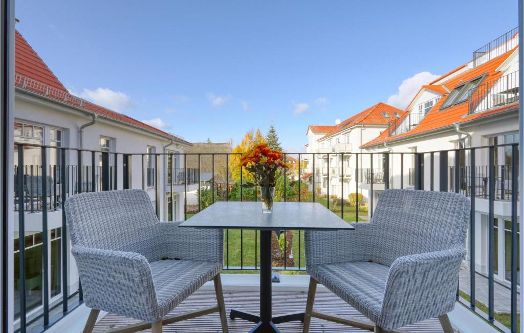 2 chaises et une table avec un vase de fleurs sur le balcon dans l'établissement Baltischer Hof Apartment 36, à Boltenhagen