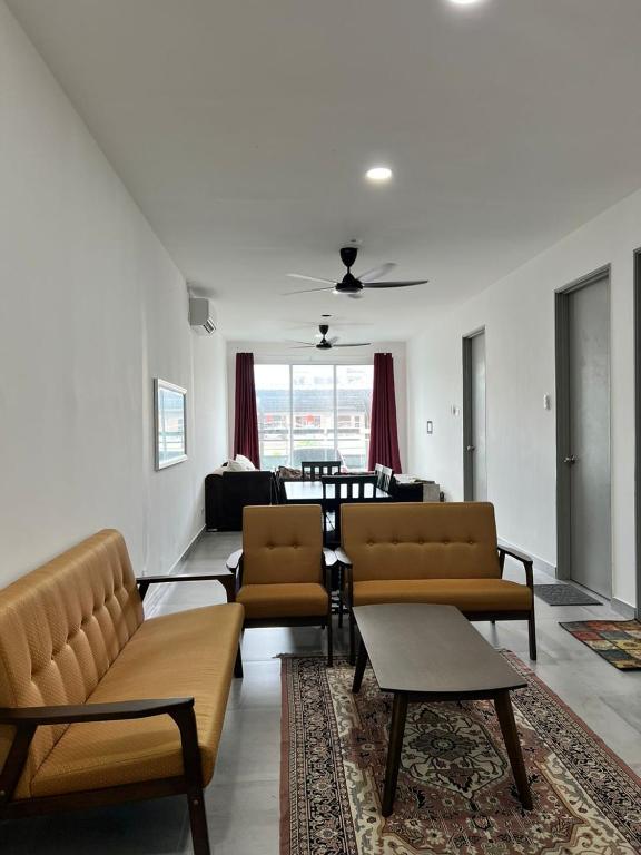 ein Wohnzimmer mit Sofas, einem Sofa und einem Tisch in der Unterkunft CHE MON Homestay in Kuching