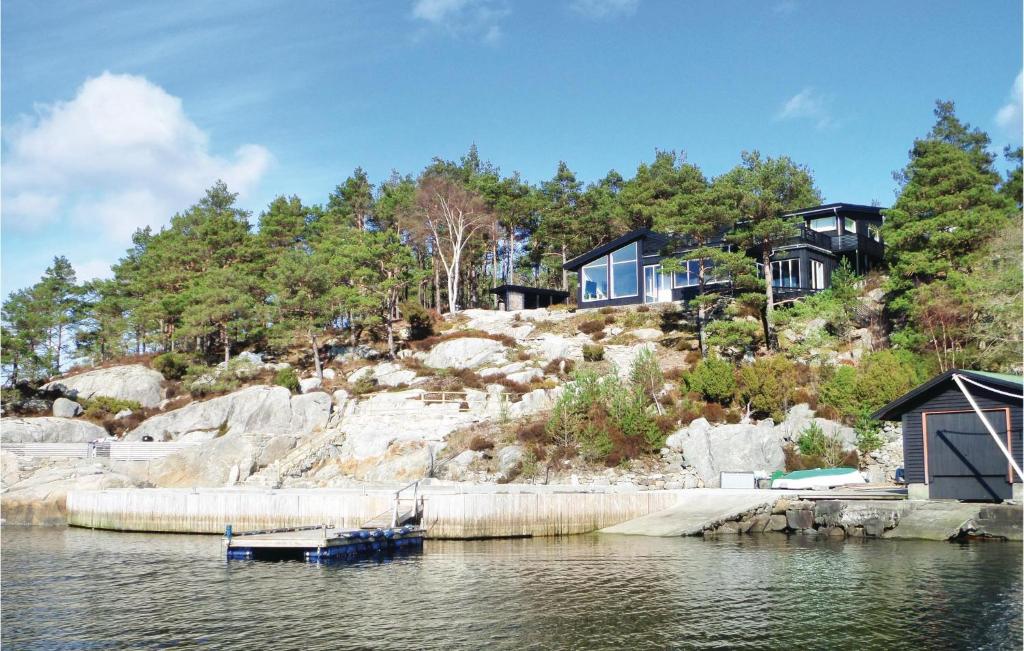 a house on a hill next to a body of water at Gorgeous Home In Sveio With Kitchen in Sveio