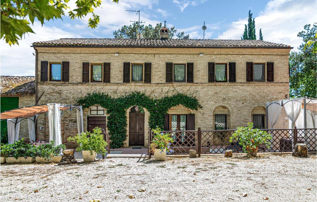 una vecchia casa di mattoni con piante davanti di Nice Home In Macerata With Wifi a Macerata