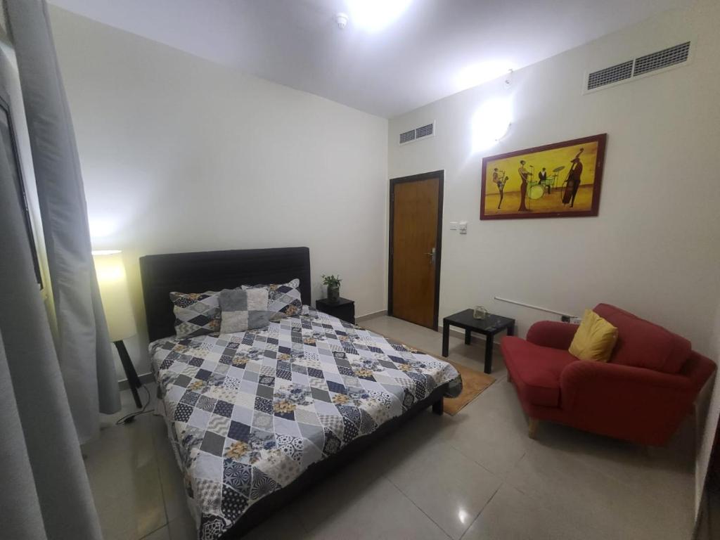 1 dormitorio con 1 cama y 1 silla roja en Luxury 3 BHK family vacation home, en Dubái