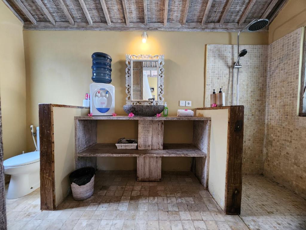 a bathroom with a sink and a toilet and a mirror at Bamboo Lodge 2 in Gili Trawangan