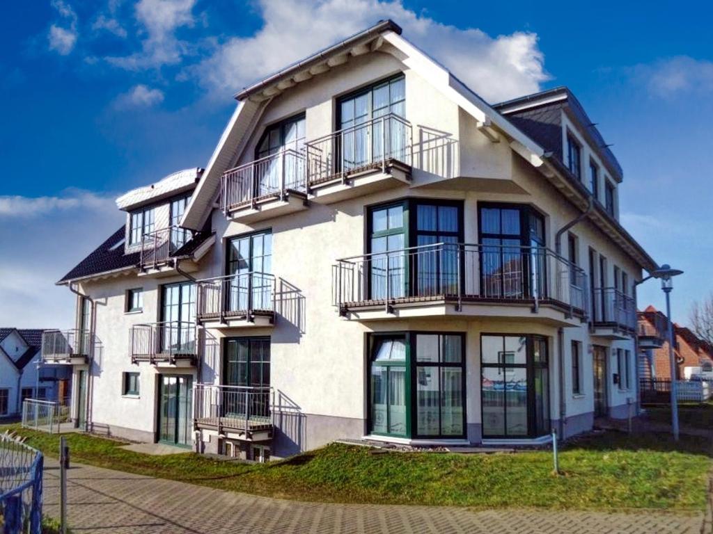 une maison blanche avec des balcons sur son côté dans l'établissement Haus Weida, à Breege