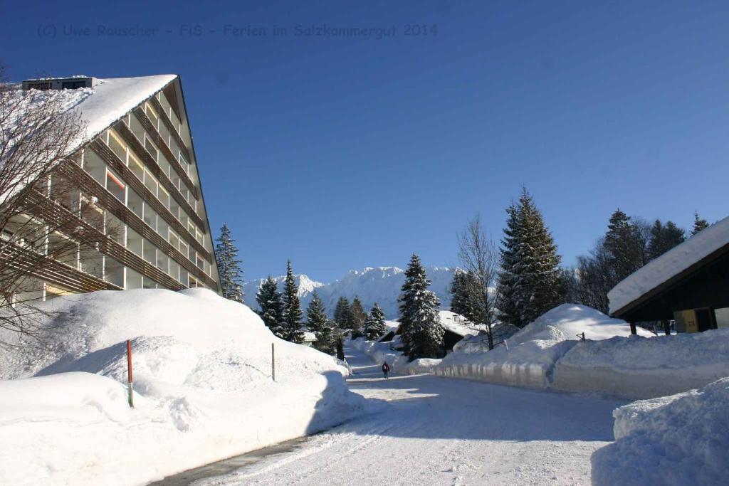 une rue recouverte de neige à côté d'un bâtiment dans l'établissement Apartment in Bad Mitterndorf - Steiermark 36988, à Bad Mitterndorf