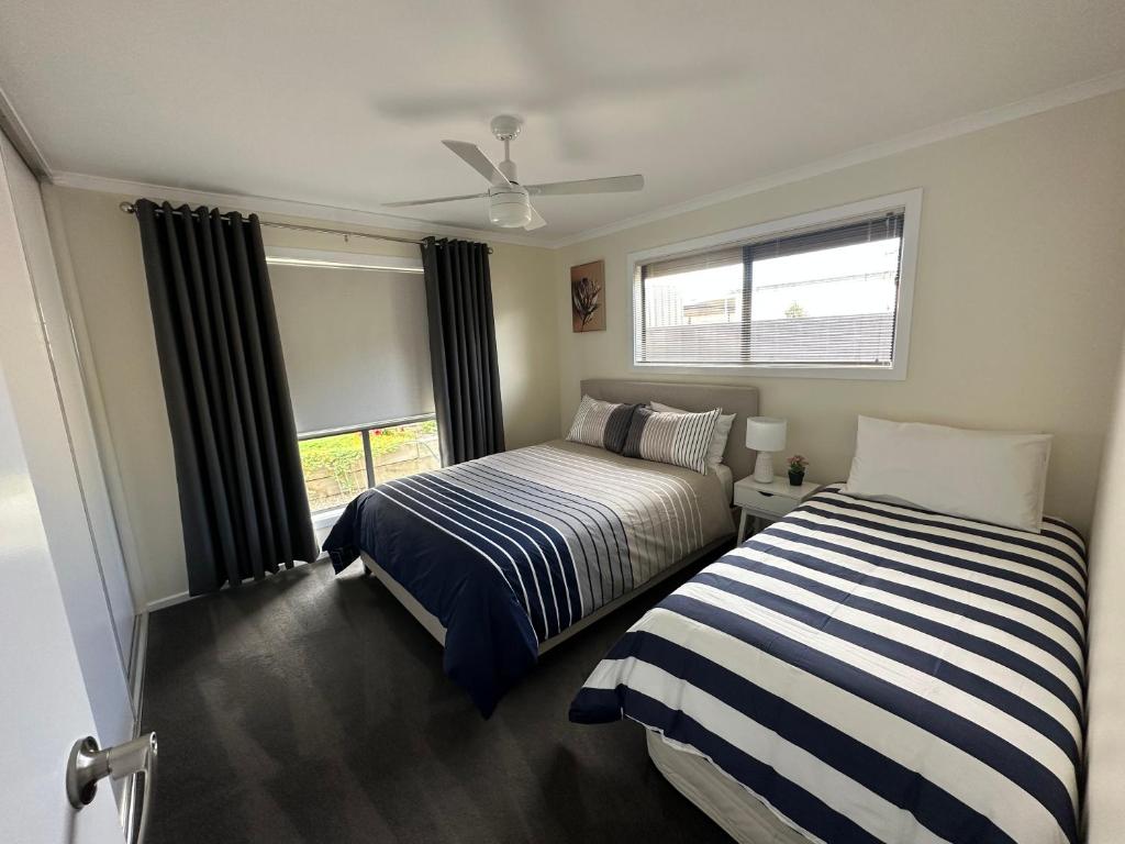 sypialnia z 2 łóżkami i oknem w obiekcie CandE on Wheelton w mieście Kingscote