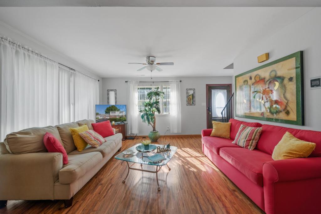 a living room with two couches and a table at Perfect Private Getaway Minutes to Virginia Beach! in Virginia Beach
