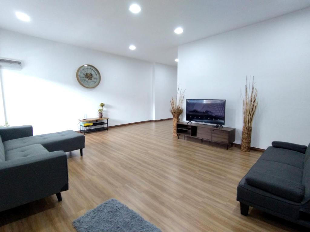 a living room with a flat screen tv and a couch at Greenery Studio, Kubot a Sentral in Tawau