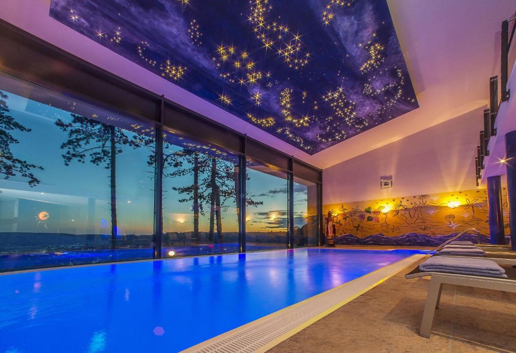 a swimming pool in a house with a ceiling filled with stars at Wellnesshotel Schönblick - Superior in Eichstätt