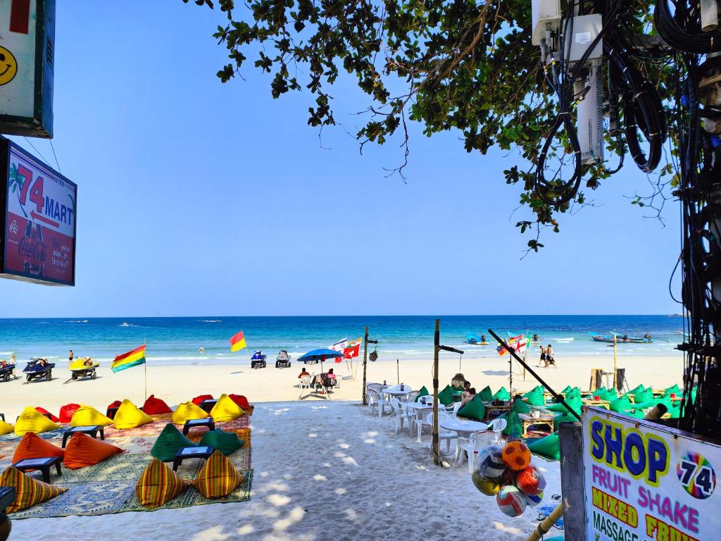 una playa con un montón de sillas y sombrillas en 74 Guest House Haad Rin, en Haad Rin