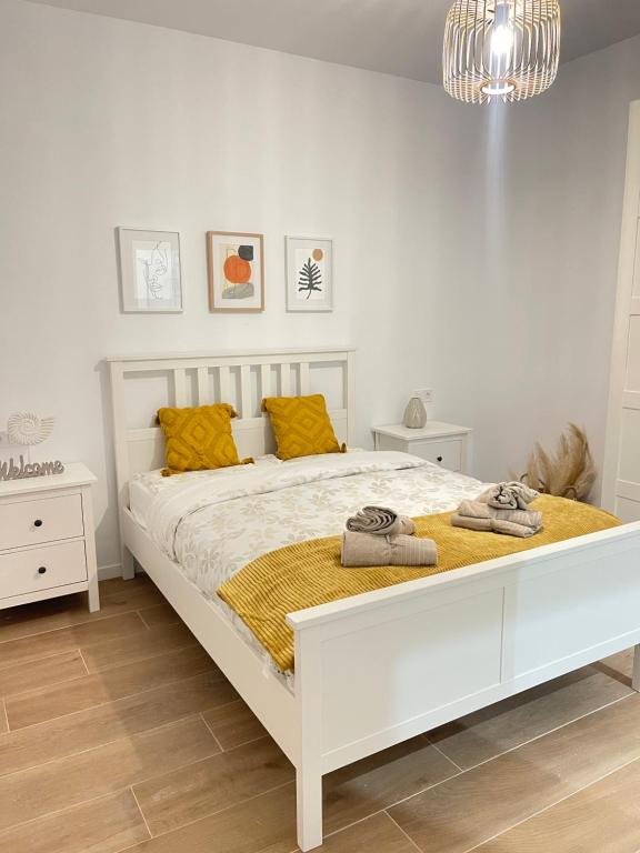 sypialnia z dużym białym łóżkiem i żółtymi poduszkami w obiekcie UIM Mediterraneo CASA Sepulveda Wifi w mieście Puerto de Sagunto