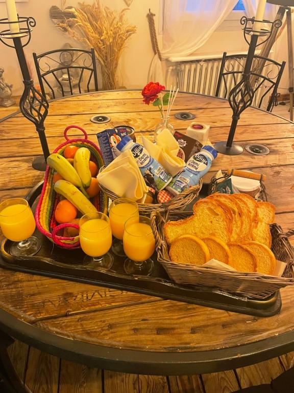 una bandeja de comida en una mesa con pan y fruta en Une ambiance cosy, en Nassandres