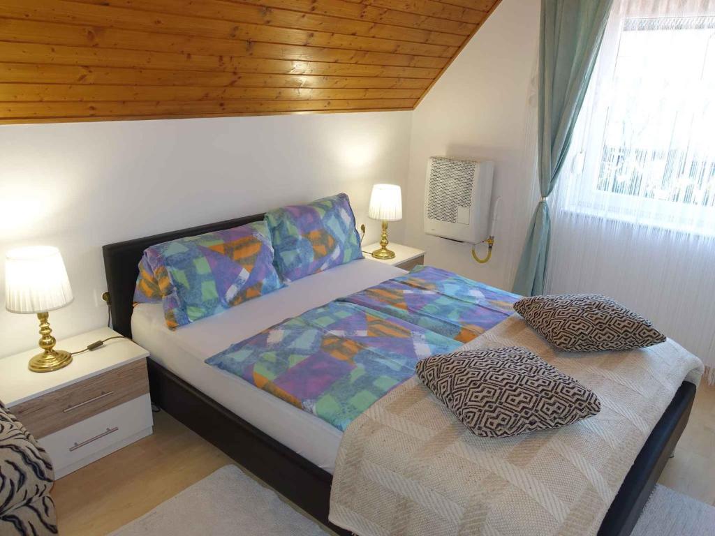 - une chambre avec un lit et une table avec deux lampes dans l'établissement Apartment in Fonyod - Balaton 43602, à Fonyód