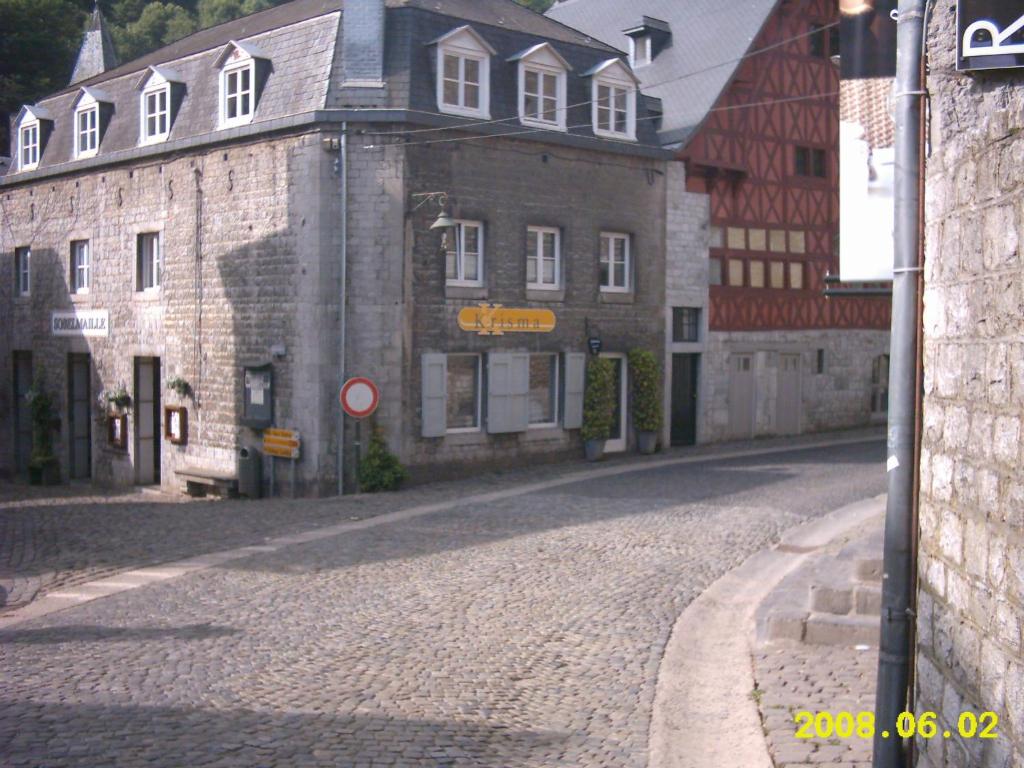 デュルビュイにあるル ステュディオ ドゥ クリスティーヌの石畳の通りに建つ古い石造りの建物