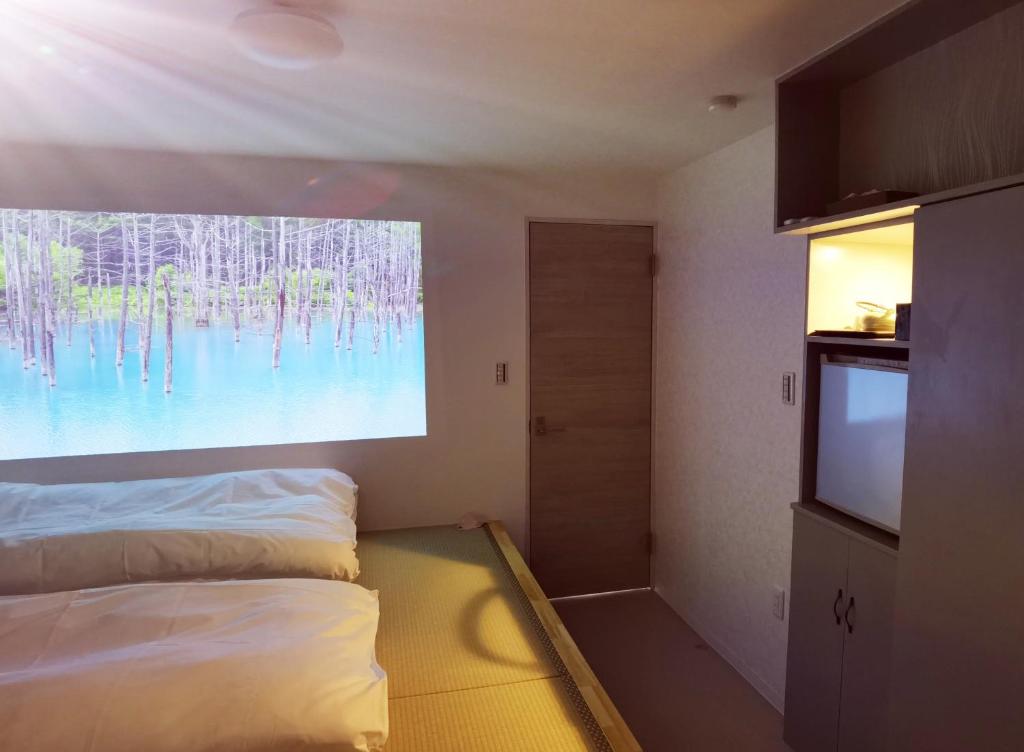 a room with a bed and a flat screen tv at Hostel Belle Via Tokyo in Tokyo