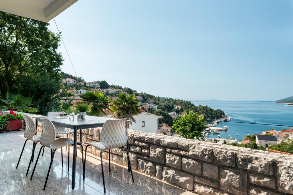 ラバックにあるApartment in Rabac 43550のテーブルと椅子、水辺を見渡すバルコニー
