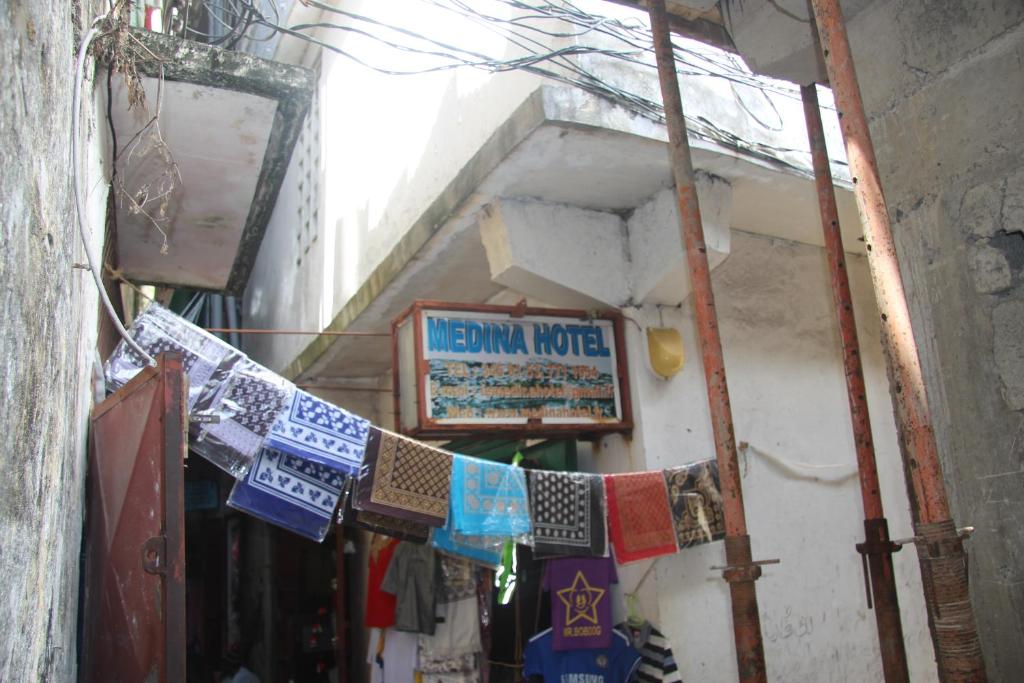 Mutsamudu的住宿－MEDINA HOTEL - Mutsamudu，一条狭窄的小巷,上面有墨西哥汽车旅馆的标志