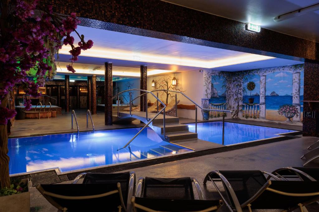 ein großer Pool mit Stühlen um ihn herum in der Unterkunft Lavendel Spa Hotel in Tallinn