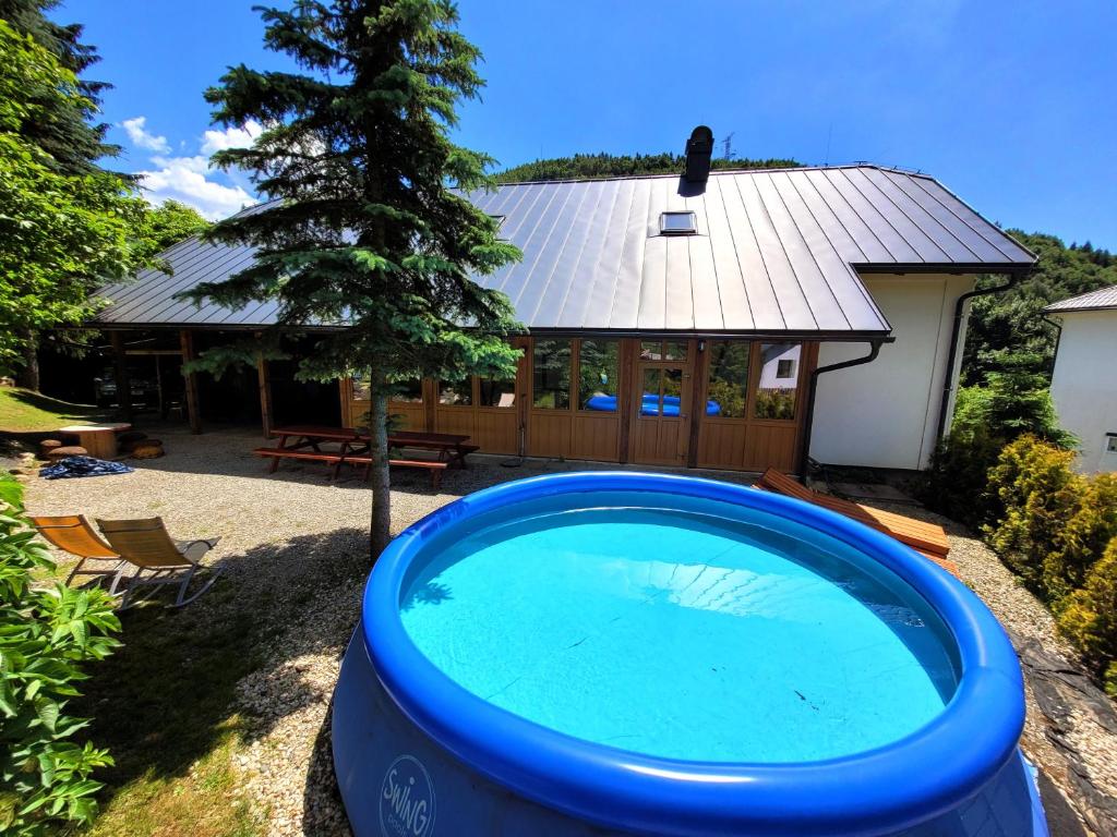a large blue pool in front of a house at Rezidence Kouty in Loučná nad Desnou