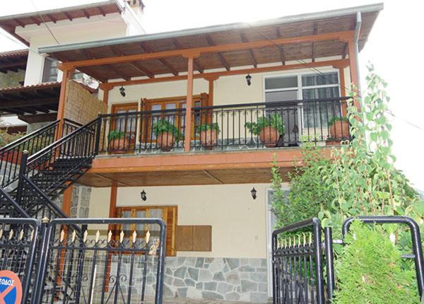 a house with a balcony with potted plants on it at Elati Apartments in Elati
