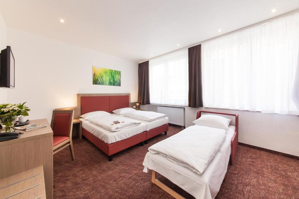 מיטה או מיטות בחדר ב-Hotel Excelsior Dortmund Hauptbahnhof