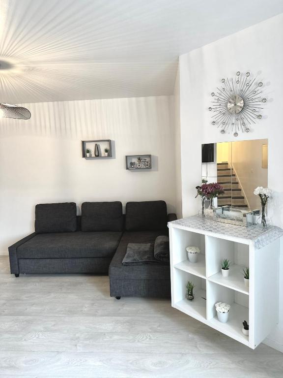 a living room with a couch and a mirror at Jolie appartement duplex 2 min gare-Disney et paris 15 min in Noisy-le-Grand