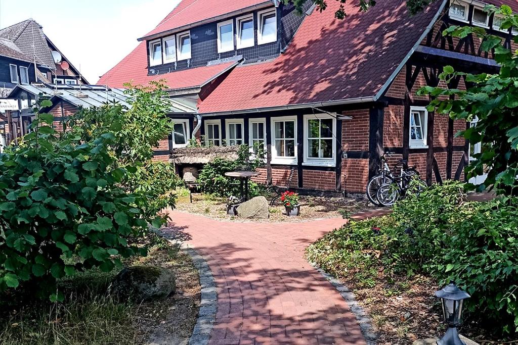 a house with a brick path in front of it at Ferien- und Reitsport Hotel Brunnenhof in Suhlendorf