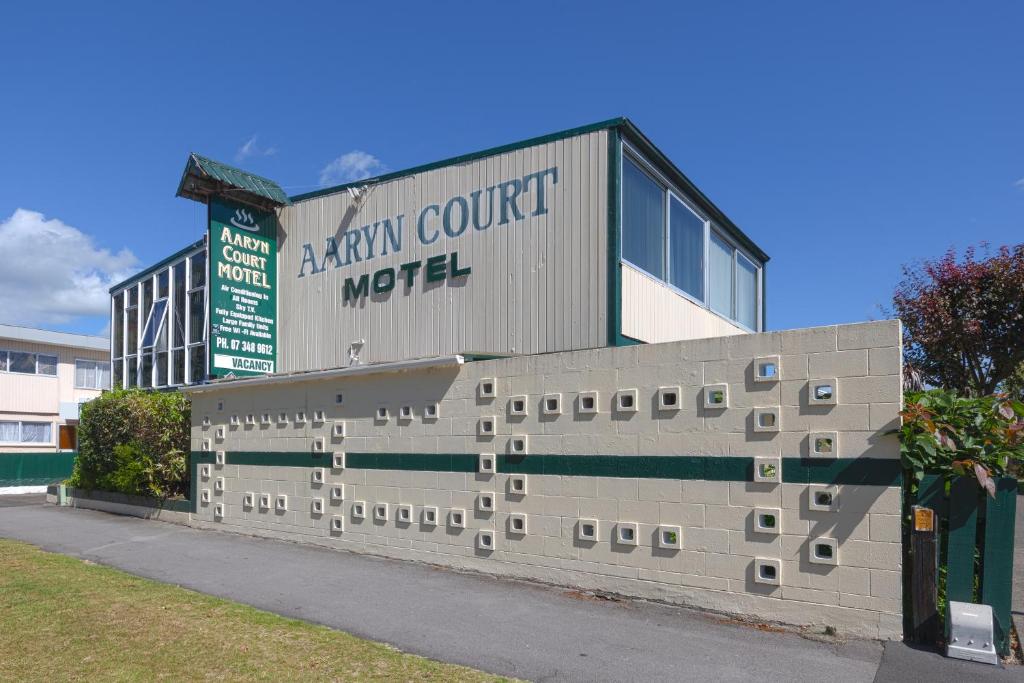een gebouw met een betonnen muur ervoor bij Aaryn Court Motel in Rotorua