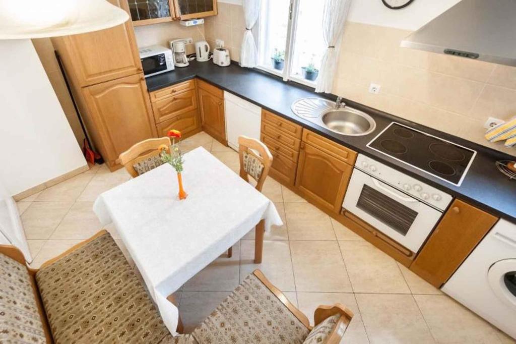 Holiday home in Budapest 34304 في بودابست: مطبخ صغير مع طاولة بيضاء وكراسي