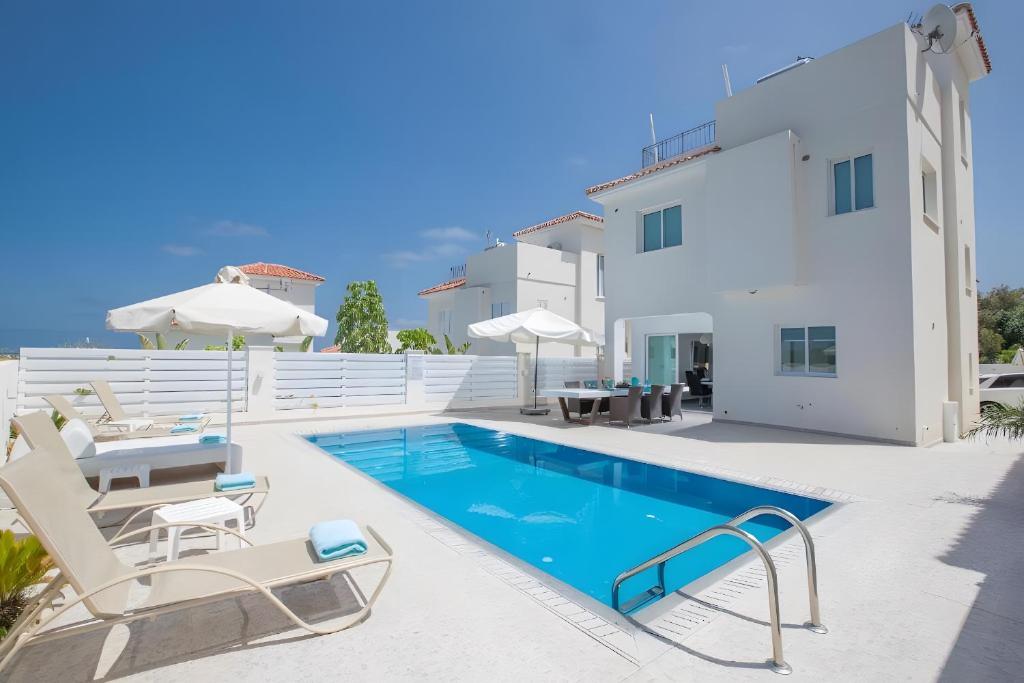 a villa with a swimming pool and patio furniture at Casa de Nicole in Protaras