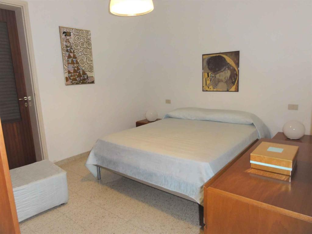 ein kleines Schlafzimmer mit einem Bett und einer Kommode in der Unterkunft Holiday home in Bibione 41086 in Bibione