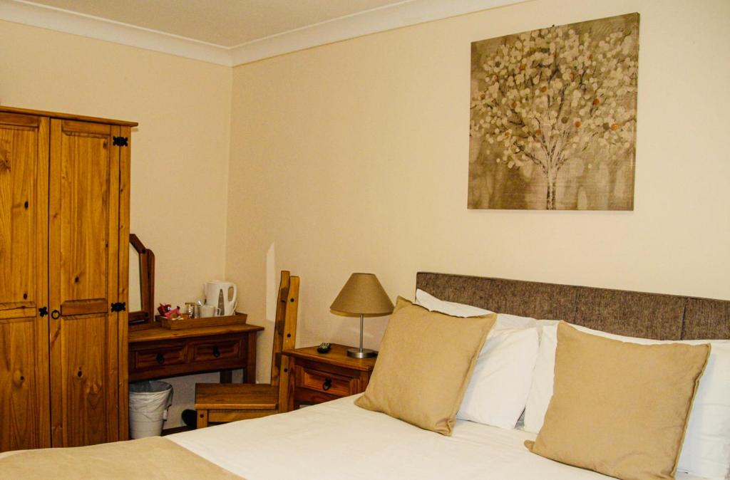 a bedroom with a bed and a table with a lamp at The Ham and Cheese in Scagglethorpe
