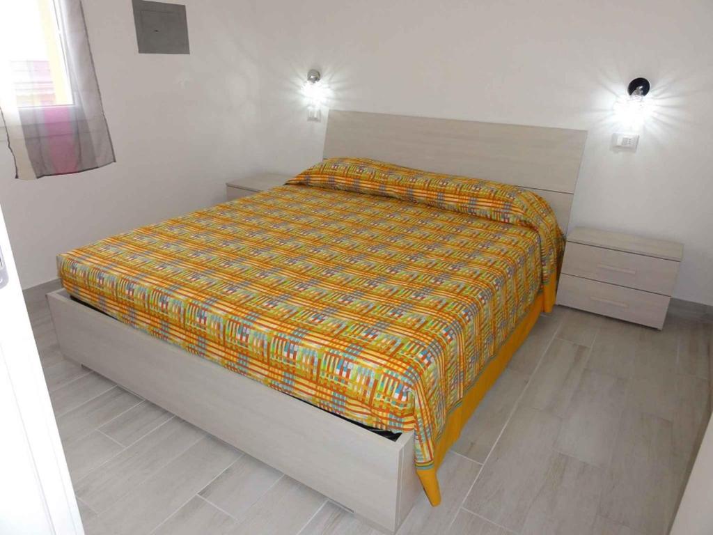 ein Schlafzimmer mit einem Bett mit einer bunten Decke darauf in der Unterkunft Apartment in Bibione 38316 in Bibione