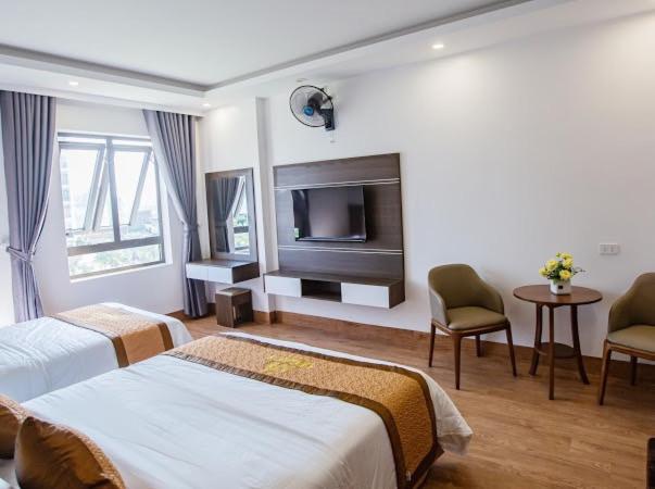 um quarto de hotel com duas camas e uma televisão de ecrã plano em Tan Truong Son Legacy Hotel em Sam Son