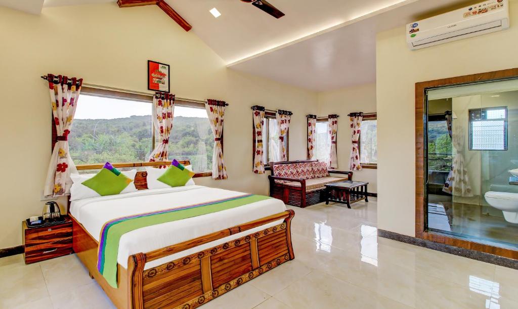 1 Schlafzimmer mit einem Bett und einem Bad in der Unterkunft Treebo Trend Garden Cottage & Lawn Mahabaleshwar in Mahabaleshwar
