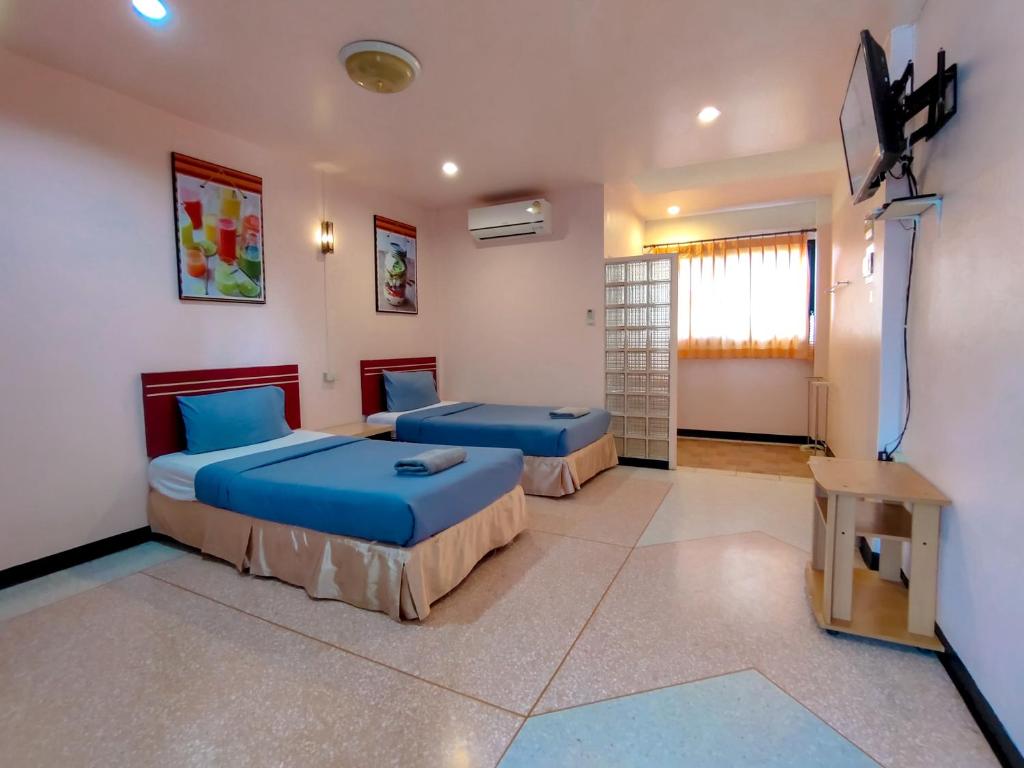 a bedroom with two beds and a flat screen tv at Srisomthai Hotel in Ubon Ratchathani