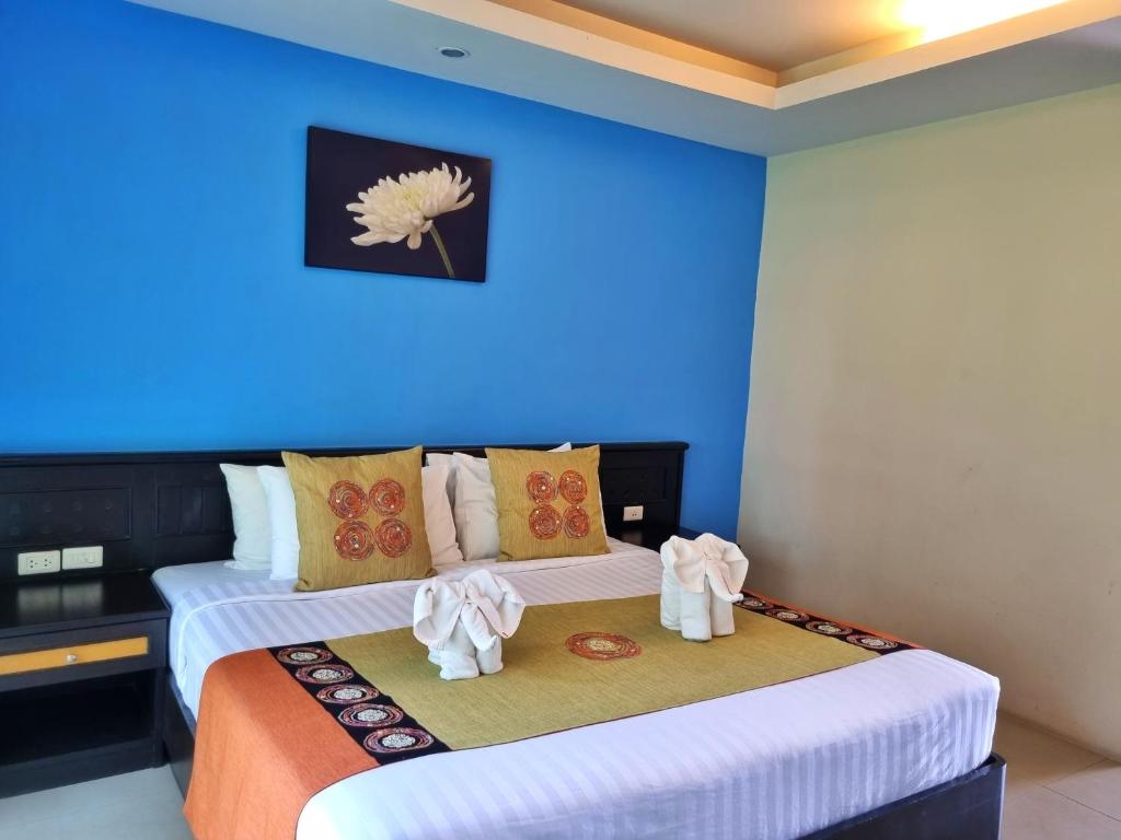 Duas camas num quarto com uma parede azul em MM Hill Koh Samui Hotel - SHA Certified em Chaweng