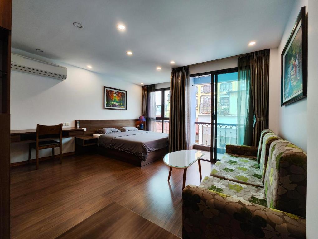 a hotel room with a bed and a couch at Zody House in Hanoi