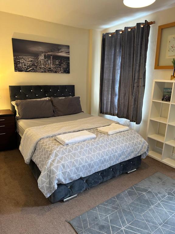 a bedroom with a bed with two towels on it at Amazing and Lovely 2- Bedroom First Floor Flat in London