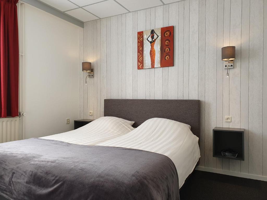 een slaapkamer met een bed en een tv aan de muur bij Appartementen Vouwere in Mechelen