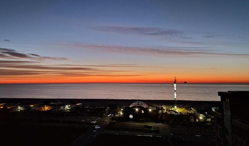 a view of the ocean at sunset from a building at Ena Sunrise Summerland in Mamaia