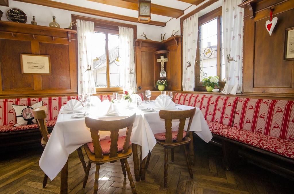 uma sala de jantar com uma mesa branca e cadeiras em Badischer Landgasthof Hirsch em Hügelsheim