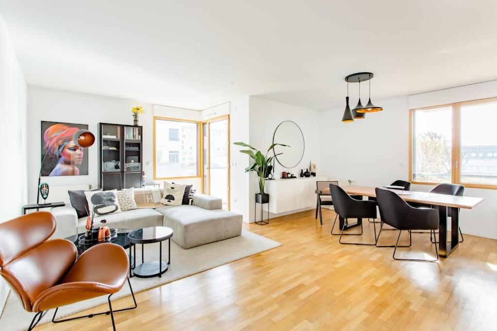 Magnifique appartement 160m2 à 15mn de Paris في فيتري-سور-سين: غرفة معيشة مع أريكة وطاولة