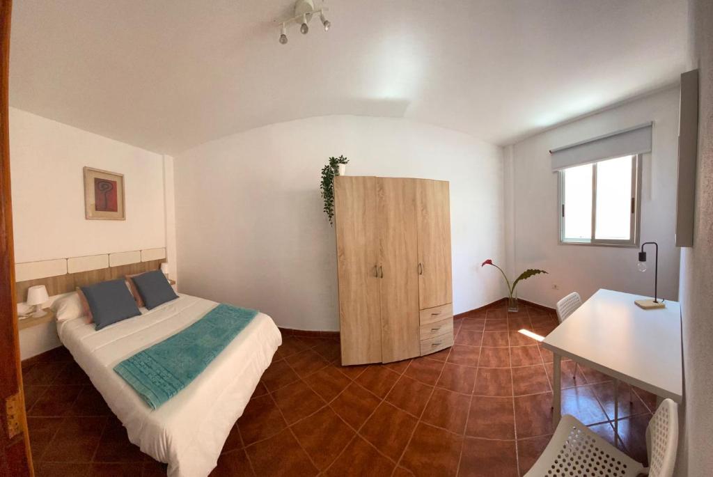 a bedroom with a bed and a wooden cabinet at CASA CORALES in La Mareta