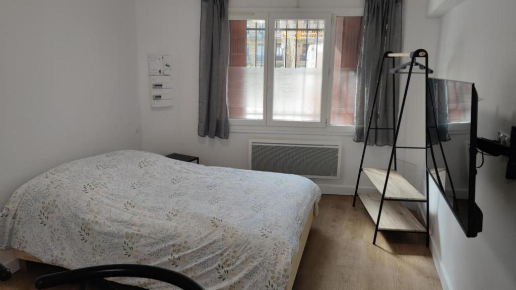 um quarto com uma cama, uma janela e um tripé em Verdier Studio Lot 1 em Toulouse