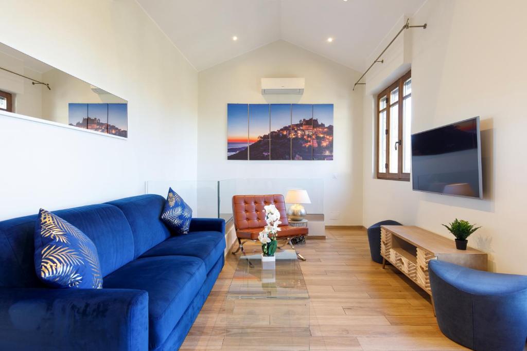 a living room with a blue couch and a table at Villa d exception avec terrasse, jacuzzi, vue mer, parking, en plein cœur du village de Eze in Éze
