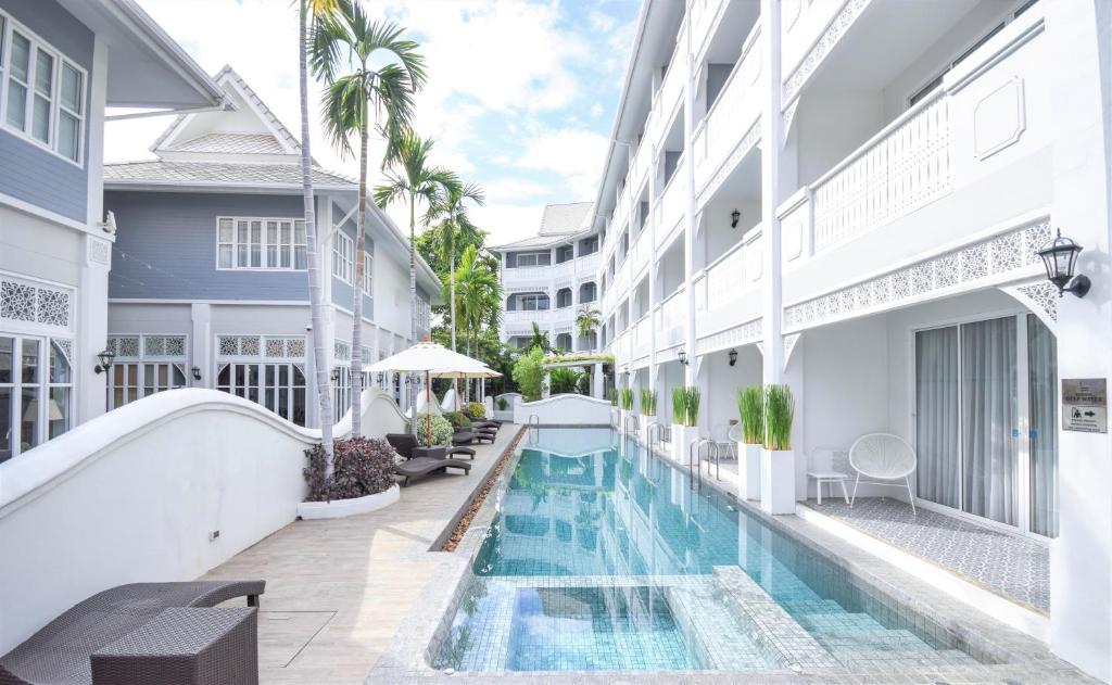 an external view of a building with a swimming pool at Away Chiang Mai Thapae Resort A Vegan Retreat - SHA Extra Plus in Chiang Mai