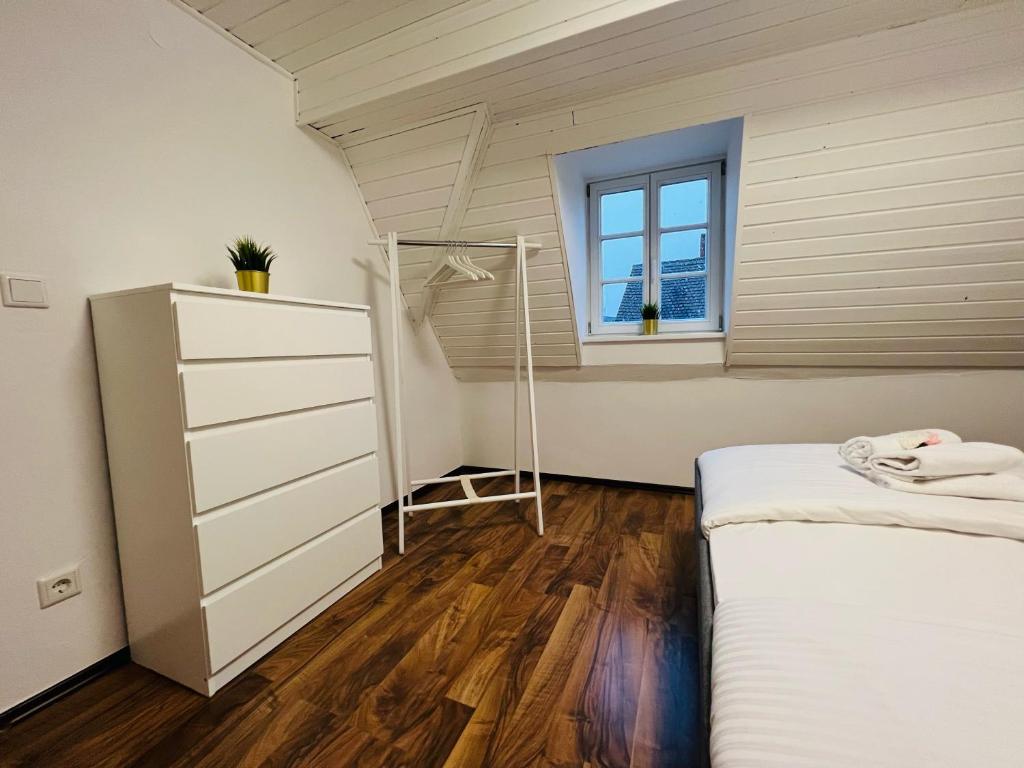 1 dormitorio en el ático con cama y ventana en Apartment Rheingold, en Schwabach