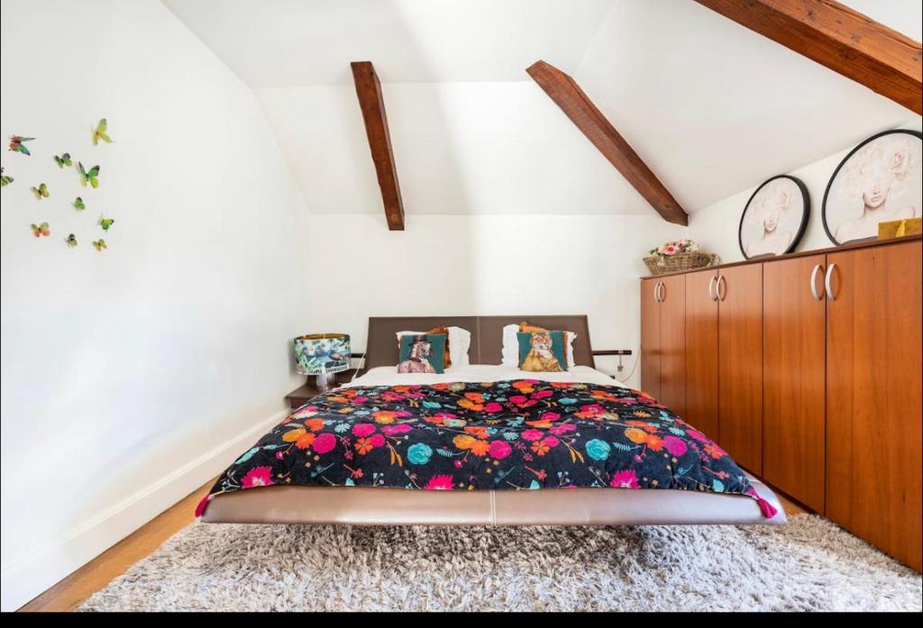 a bedroom with a bed with a floral bedspread at Villa Bonnabel in Nancy